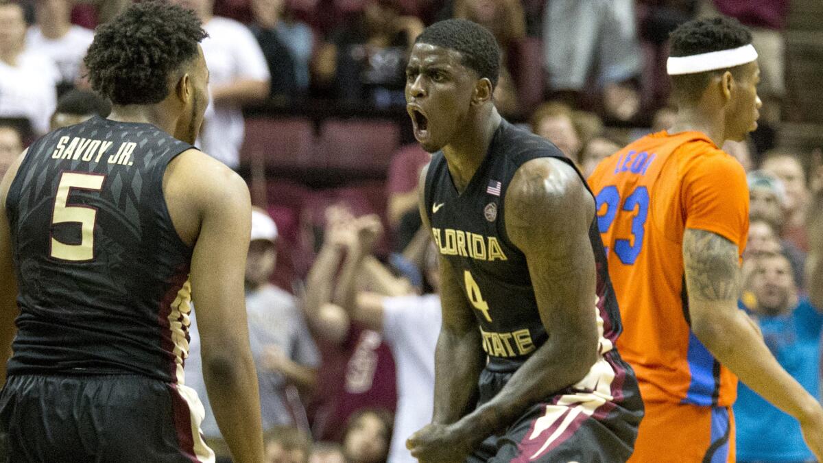 Florida State's Dwayne Bacon, Jr. (4) celebrates a basket with teammate PJ Savoy (5) in the first half of their game against Florida on Sunday.