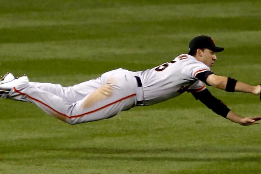 Giants left fielder Travis Ishikawa makes a diving catch on a ball hit by Cardinals catcher Yadier Molina during the fourth inning of Game 1 in the NLCS on Saturday.