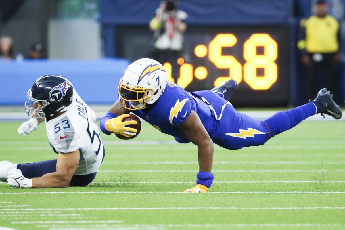 Chargers tight end Gerald Everett, right, dives for extra yardage after being tackled by Titans linebacker Dylan Cole.