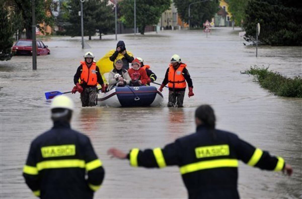 A firemen evacuate local people from flooded houses in Troubky, Northern Moravia, Czech Republic, on Tuesday, May 18, 2010. Troubky, a village of about 2000 inhabitants, is considered a symbol of the disastrous floods in Moravia in 1997 which killed nine people and demolished more than a half of the houses in the village. Current floods caused by heavy rain have been hitting northern and central Moravia since Saturday. (AP Photo,CTK/Vladislav Galgonek)