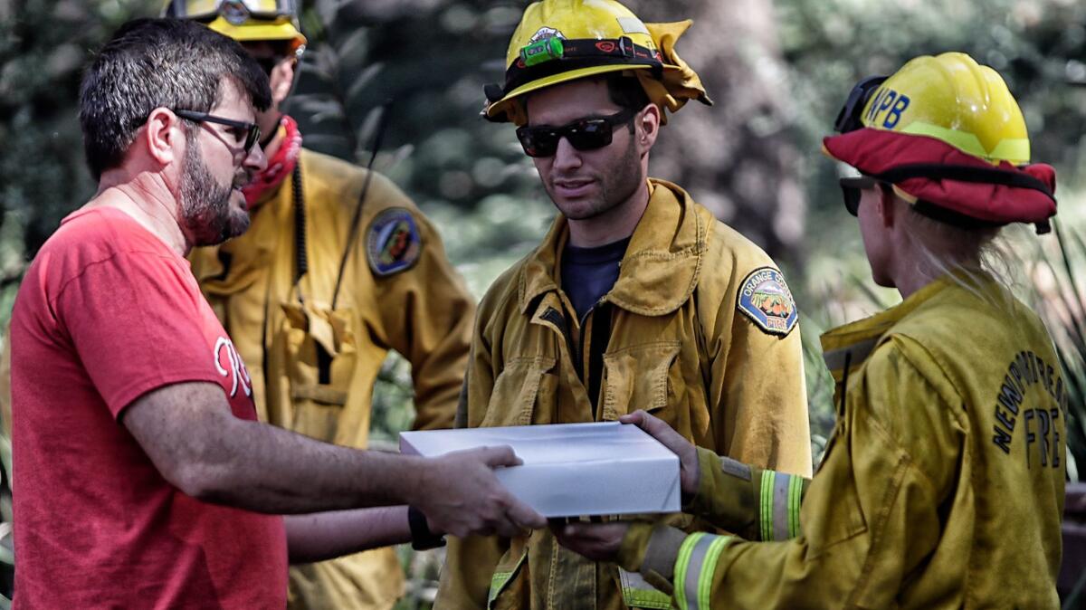 Adrian Pop delivers croissants to Newport Beach fire fighter Erin Brown.