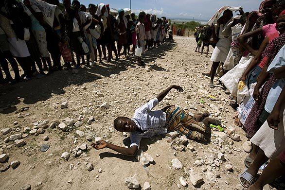 A woman falls as flood victims line up to receive food from UN peacekeepers in hurricane-stricken Gonaives, Haiti, on Thursday. Food and fresh water ran dangerously low for thousands in Gonaives and surrounding areas, as governments and aid groups struggled to help people stranded at shelters, officials said.