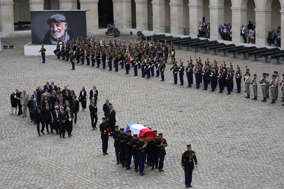 Republican Guards carry the coffin of Jean-Paul Belmondo after a tribute ceremony for the late French actor at the Hotel des Invalides, Thursday, Sept.9 2021 in Paris. The tributes for the star of iconic French New Wave film "Breathless" reflect his prominent role in France's cultural world and in living rooms, where families gathered around his films. Belmondo, whose crooked boxer's nose and rakish grin made him one of the country's most recognizable leading men, died at 88 earlier this week. (AP Photo/ Michel Euler)