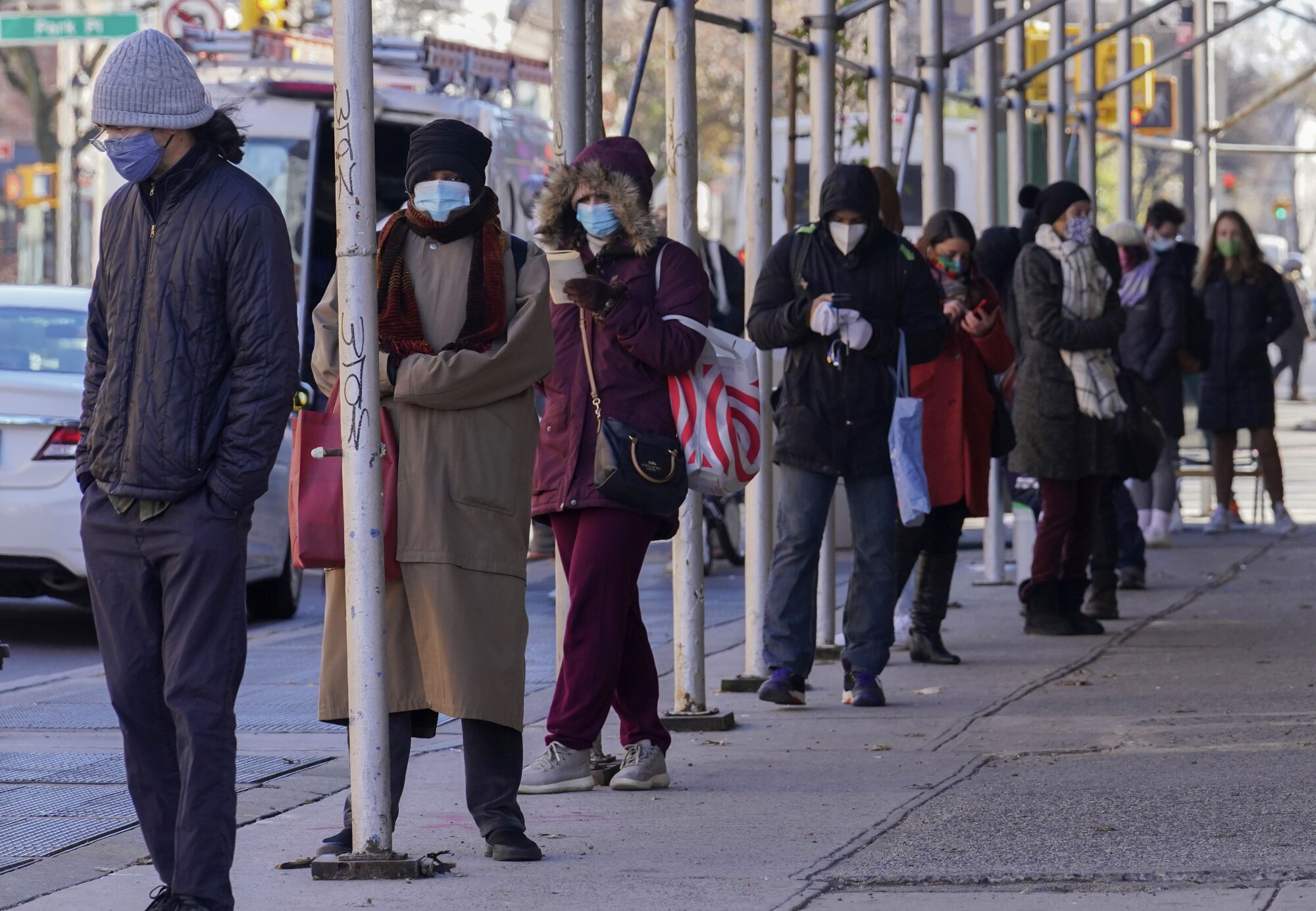 People wait in a line stretching around a block, outside a CityMD urgent care clinic offering COVID-19 testing in New York.