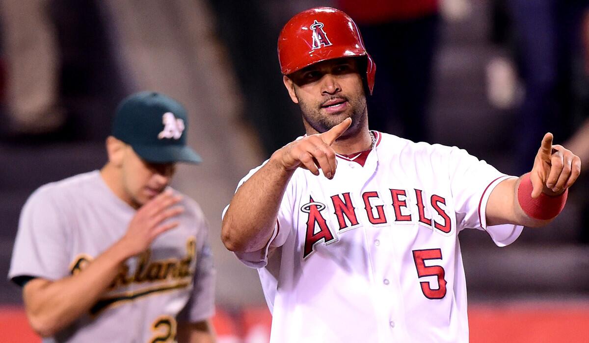 Angels' Albert Pujols reacts after scoring a run during the fifth inning Tuesday. That's Oakland's Pat Venditte in the background.