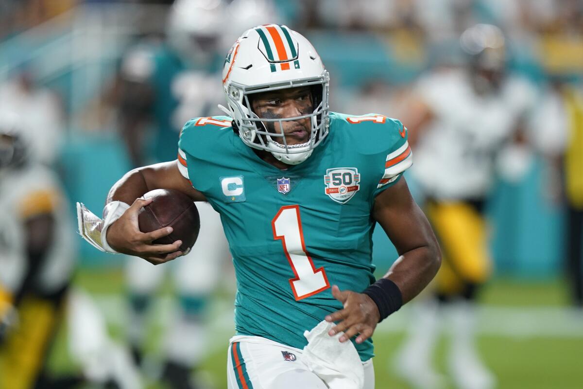 Miami Dolphins quarterback Tua Tagovailoa runs with the ball against the Pittsburgh Steelers.