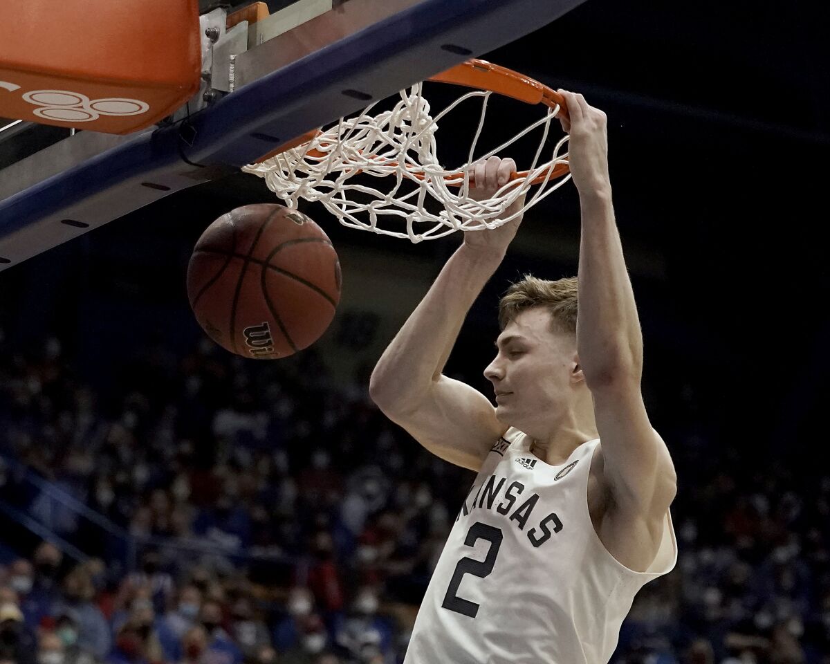 Kansas guard Christian Braun (2) dunks the ball during the first half of an NCAA college basketball game against Oklahoma State Monday, Feb. 14, 2022, in Lawrence, Kan. (AP Photo/Charlie Riedel)