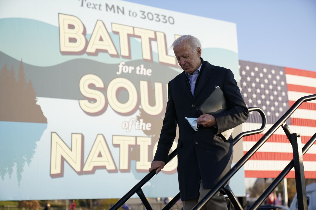 Democratic presidential candidate former Vice President Joe Biden holds his face mask after speaking at a rally at the Minnesota State Fairgrounds in St. Paul, Minn., Friday, Oct. 30, 2020. (AP Photo/Andrew Harnik)