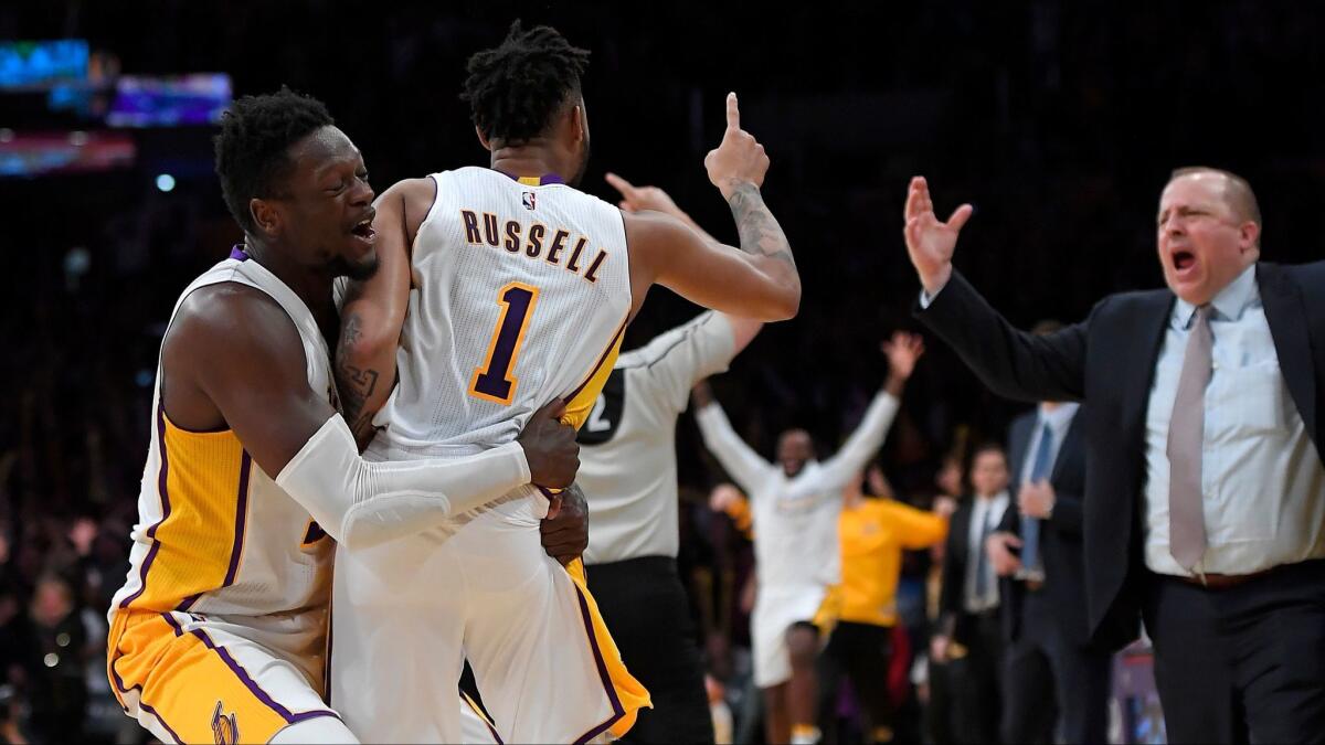Lakers guard D'Angelo Russell is hugged by Julius Randle after hitting the game-winning three point shot.