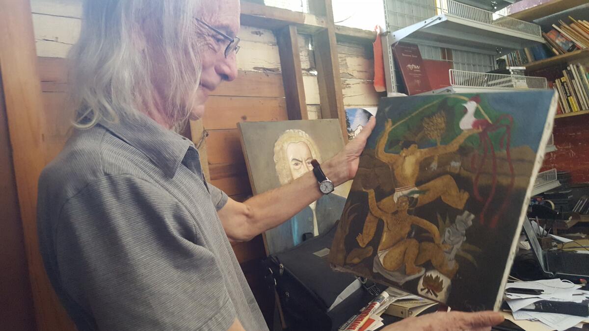 Father Jack Warner admires a painting created by an actor who performs in the Teatro la Fragua in El Progreso, Honduras.