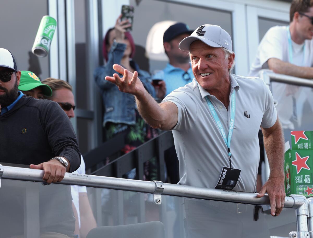 Greg Norman, chief executive of LIV Golf, tosses a beer to spectators into the crowd during the Portland Invitational.