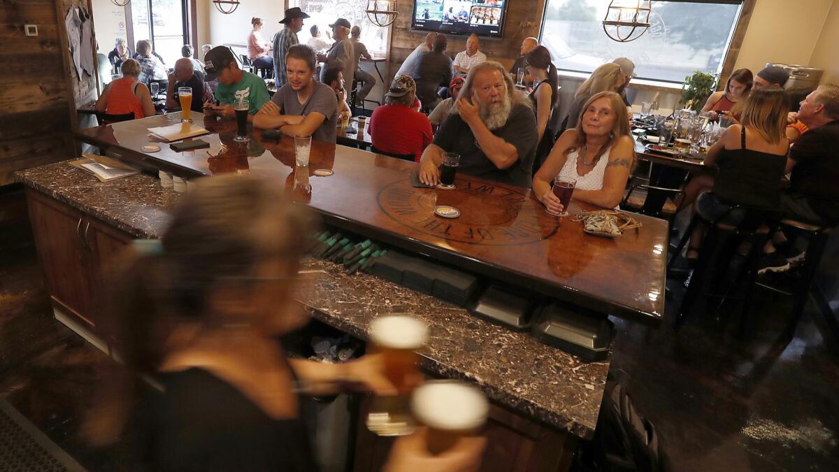 Locals enjoy a craft beer at the Edge of the World Brewery and Pub in Colorado City, a town once largely hidden from view when it was controlled by a religious cult leader.