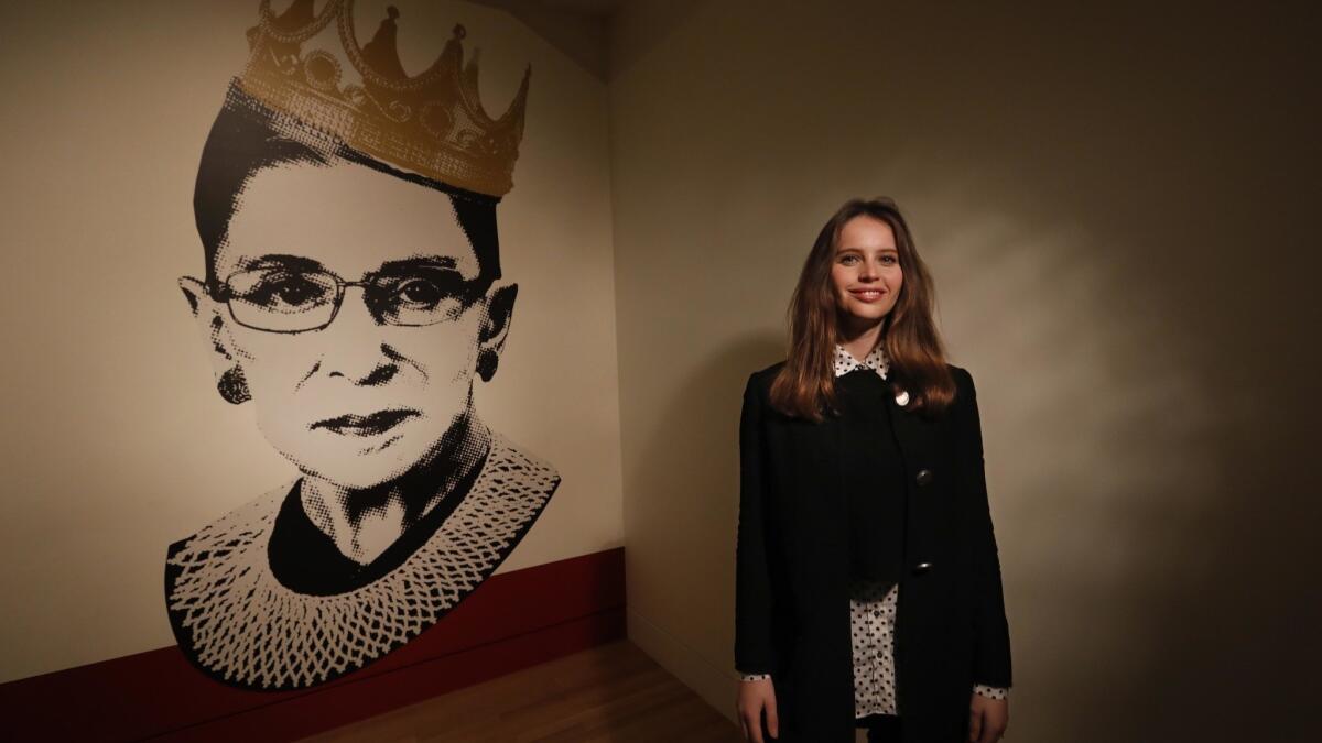 Felicity Jones poses near an image of Justice Ruth Bader Ginsburg at the exhibit "Notorious RBG: The Life and Times of Ruth Bader Ginsburg" at the Skirball Cultural Center.