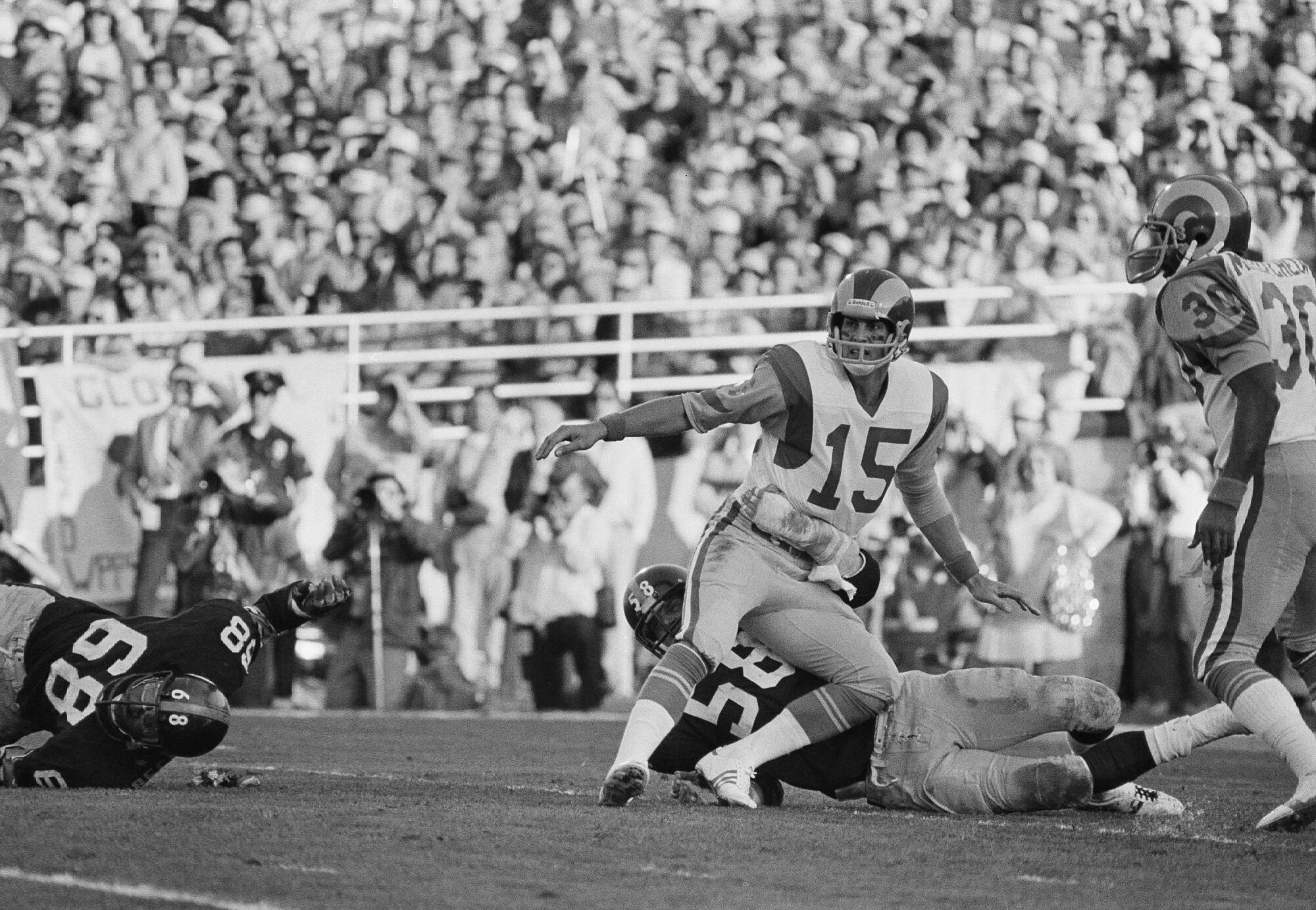 Rams quarterback Vince Ferragamo watches his pass as he gets pulled down by Pittsburgh Steelers' Jack Lambert.