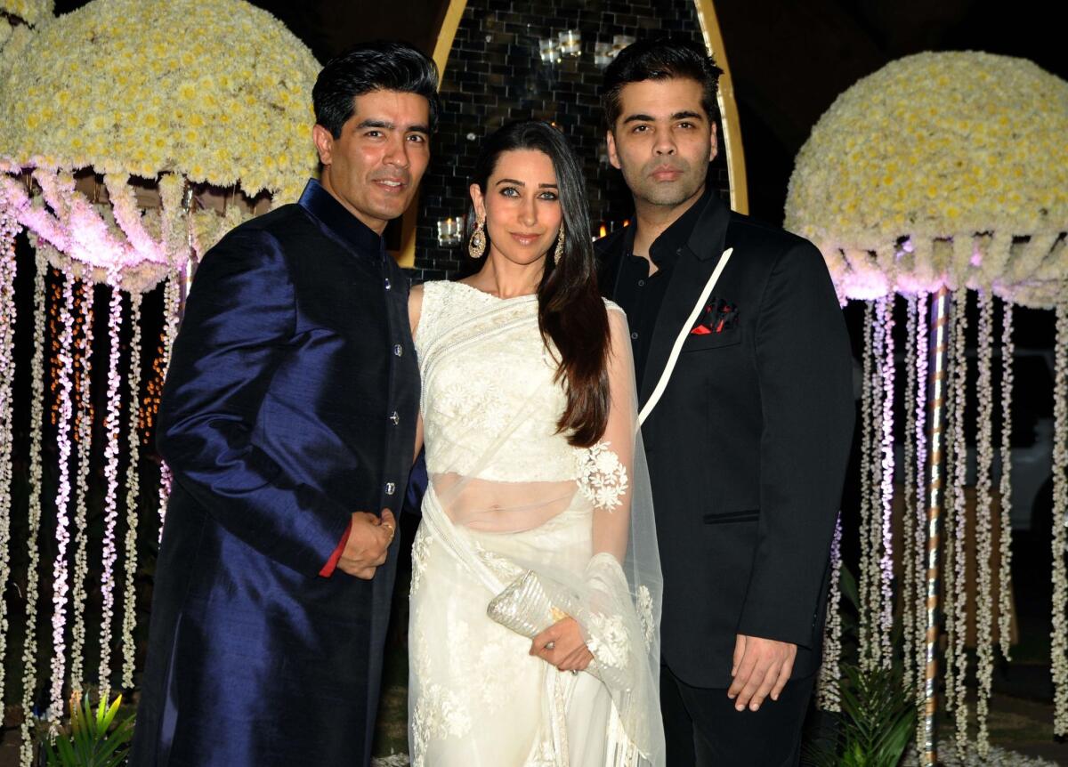 Bollywood producer Karan Johar, right, shown at a Dec. 14, 2014, wedding with actress Karishma Kapoor and designer Manish Malhotra, was one target of the ribald humor on the "Knockout" program.
