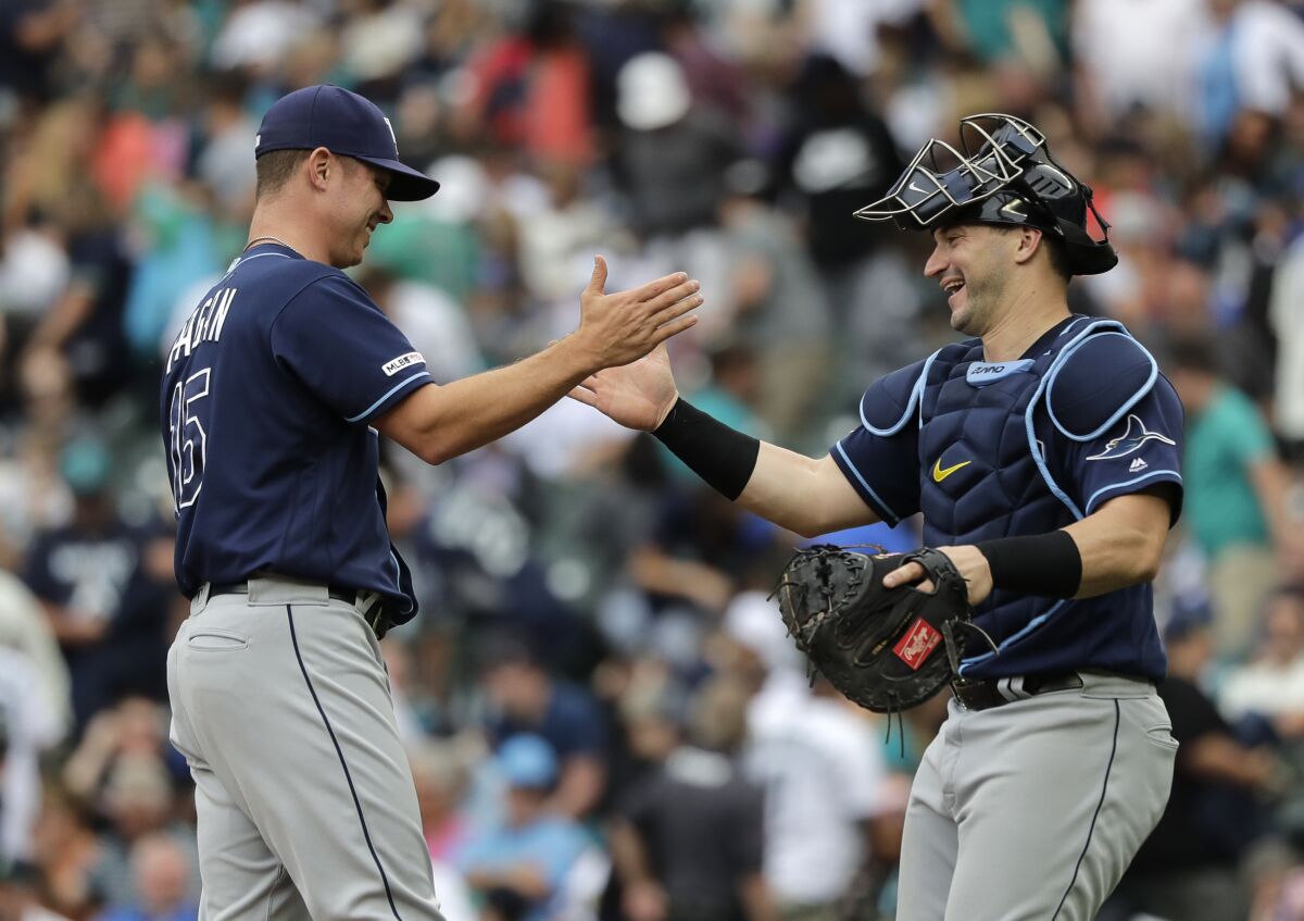 Tampa Bay Rays catcher Mike Zunino, right, greets pitcher Emilio Pagan, left, after Pagan earned the save against the Seattle Mariners in an August game.