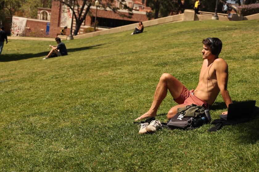 Los Angeles, CA - April 28: UCLA Student Marcus Grijalva bask in the sun on the UCLA lawn on Sunday, April 28, 2024 in Los Angeles, CA. (Michael Blackshire / Los Angeles Times)