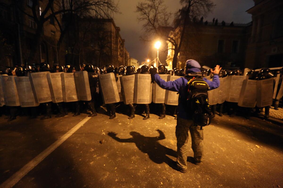 A protester faces riot troops near the Presidential Administration building in downtown Kiev on Sunday evening.