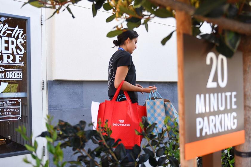 DoorDash deliverer Ricky Sierra picks up an order at Mendocino Farms in El Segundo.