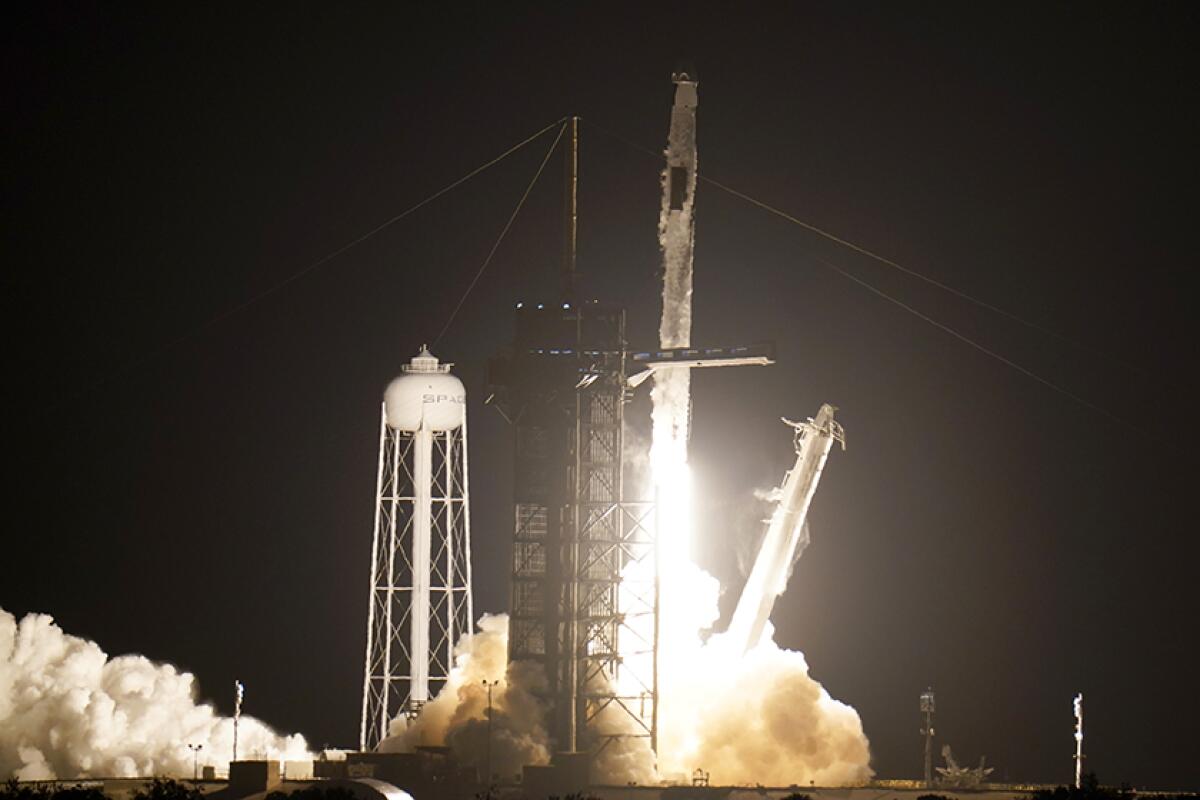 A rocket blasts off at night.