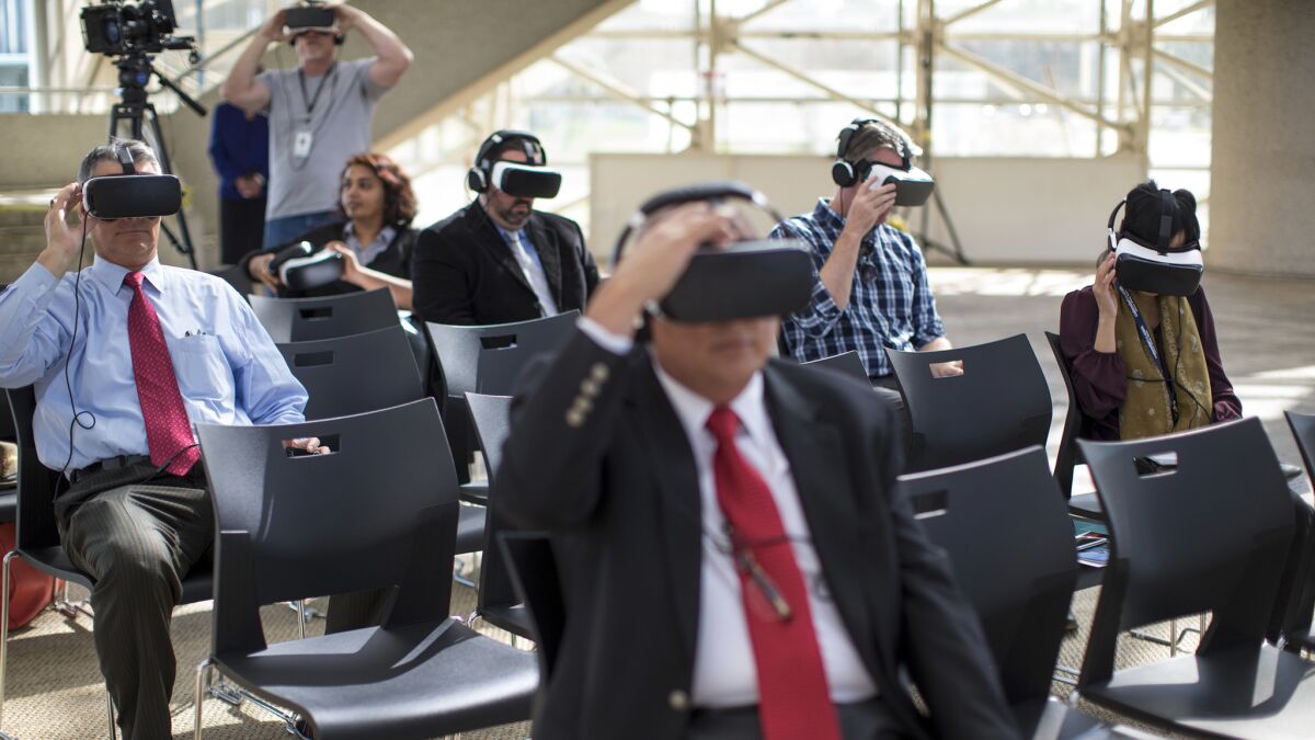 Invited guests and media watch a virtual reality tour of the multimillion-dollar renovation of the Christ Cathedral on Wednesday in Garden Grove.