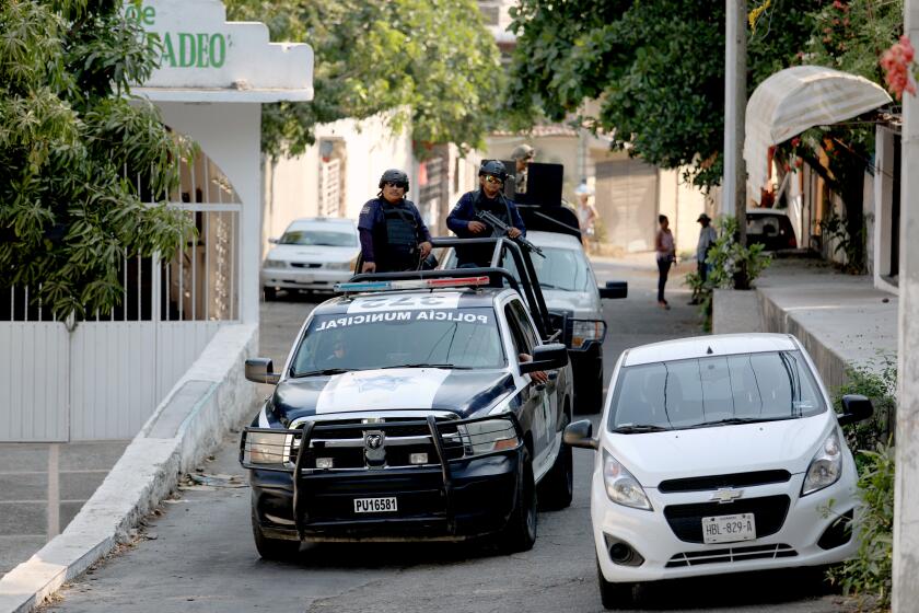 ACAPULCO, GUERRERO -- FRIDAY, APRIL 26, 2019: Municipal police patrol nearby a homicide scene where a male, roughly 20-25 years of age, was shot in the head at 6:30 a.m., in colonia Vicente Guerrero in Acapulco, Guerrero, on April 26, 2019. For years, Acapulco has been a murder capital of Mexico, with 874 homicide cases opened in 2018, up slightly from the year before. (Gary Coronado / Los Angeles Times)