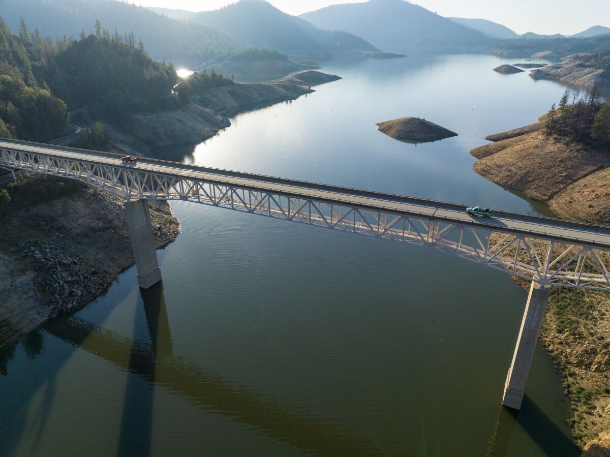 Vehicles cross a bridge over a large lake