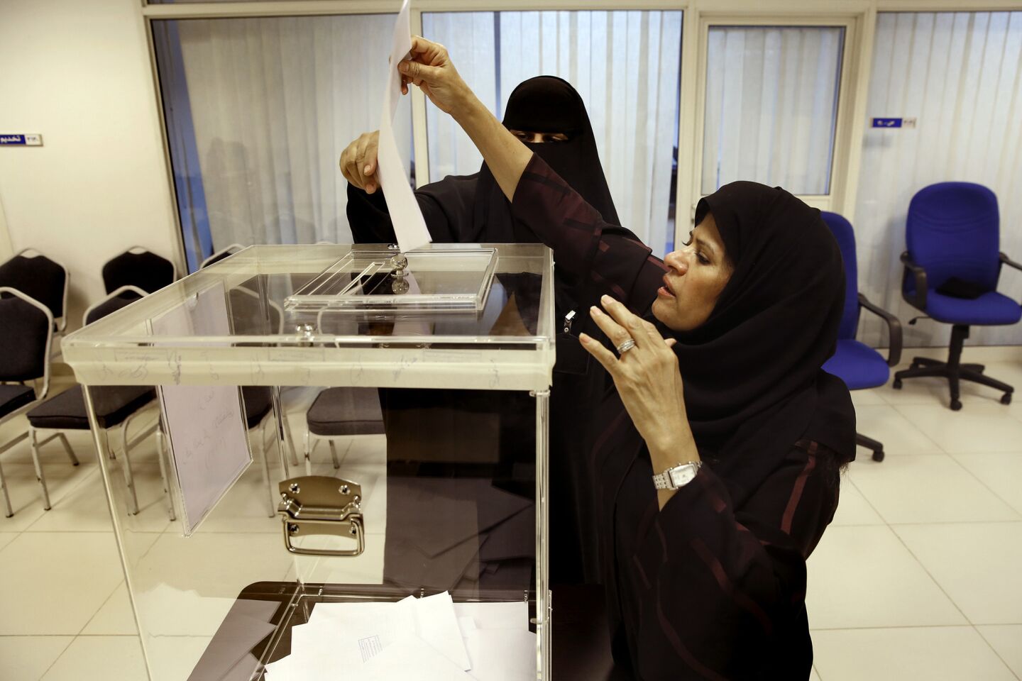Noura Alghanem, right, votes for the first time in her life, at the age of 59. "It's historic for Saudi women," she said. "It's important for women to do their part in society."