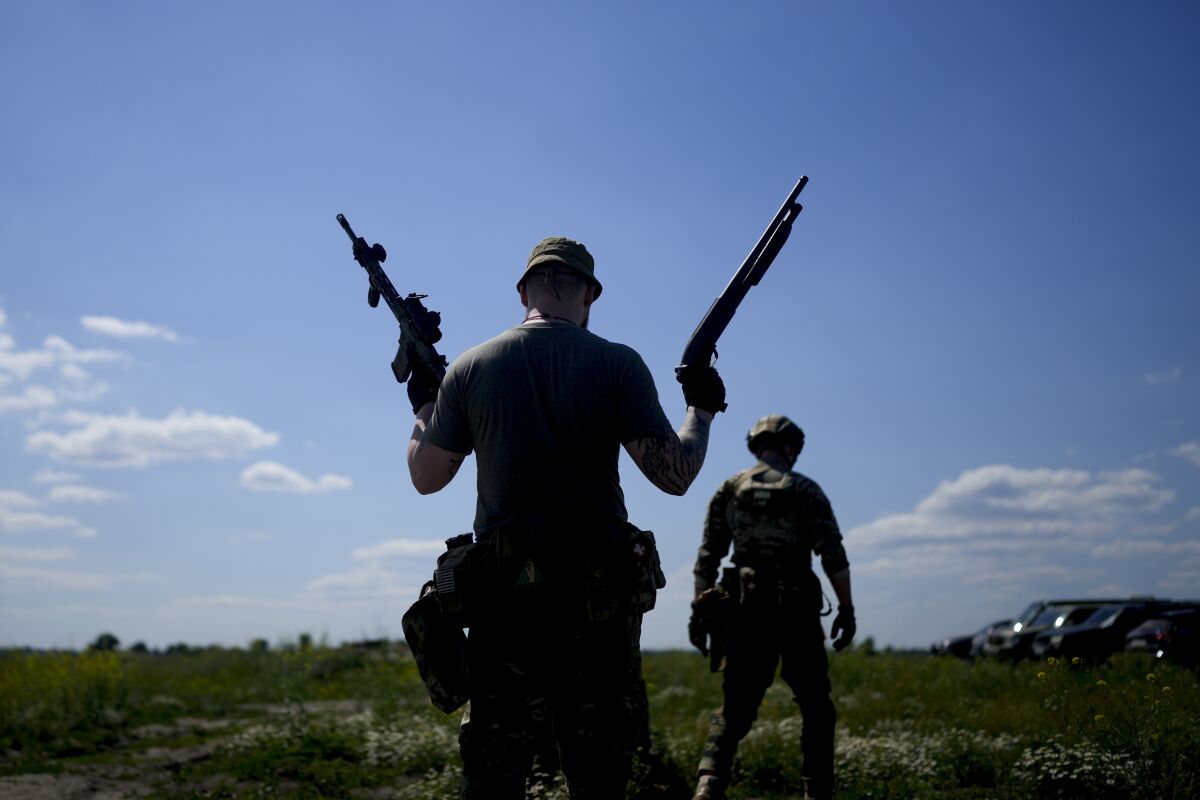 Ukrainian militia member holding a shotgun and a rifle