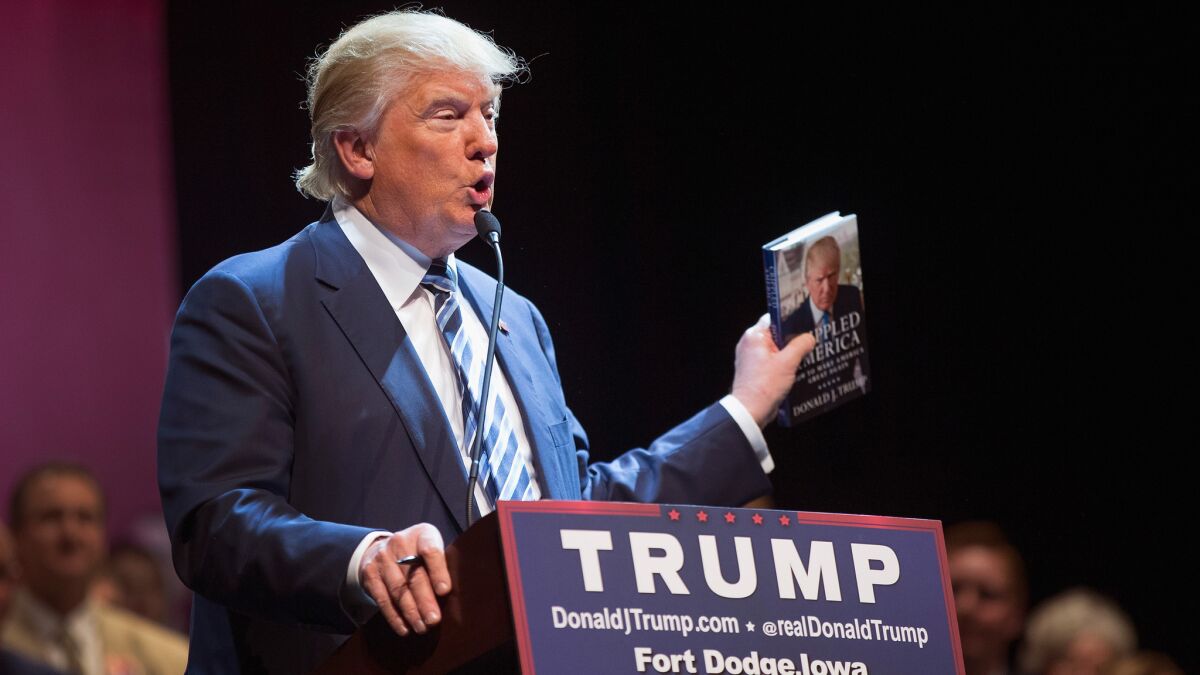 Donald Trump with his book "Cripped America" in November. He is the subject of a new biography, coloring book and more.