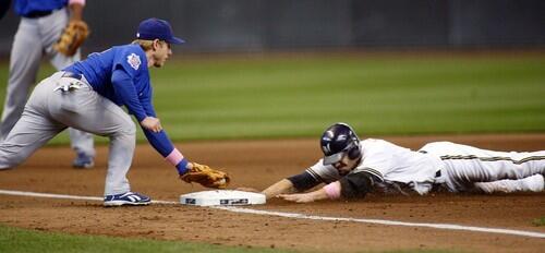 Milwaukee Brewers' Jason Kendall, right, is safe at third with a triple as Chicago Cubs' Mike Fontenot is late with the tag in the second inning of a baseball game May 10 in Milwaukee.