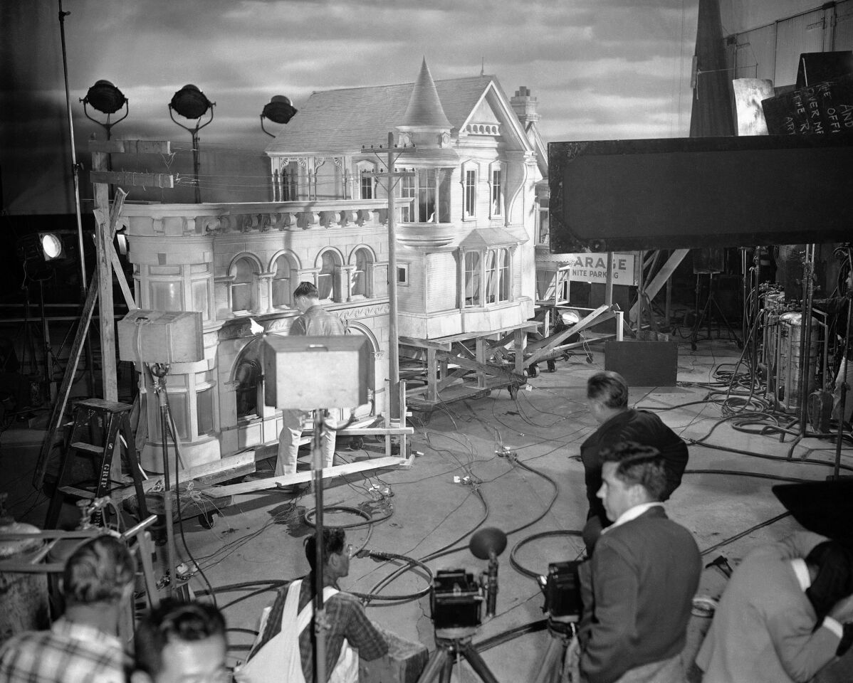 Technicians rig wires and charges in preparation for blasts and fires to be set off in buidings along a recreated Los Angeles street for the film "The War of the Worlds" on June 6, 1952. The houses are painted to match existing buildings in Los Angeles.