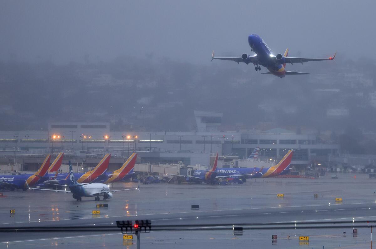 A Southwest Airlines jet takes off toward the east at San Diego International airport as a storm moved in.