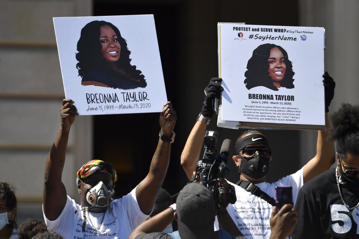 Protesters hold signs showing Breonna Taylor during a rally in her honor at the Kentucky state Capitol in Frankfort.