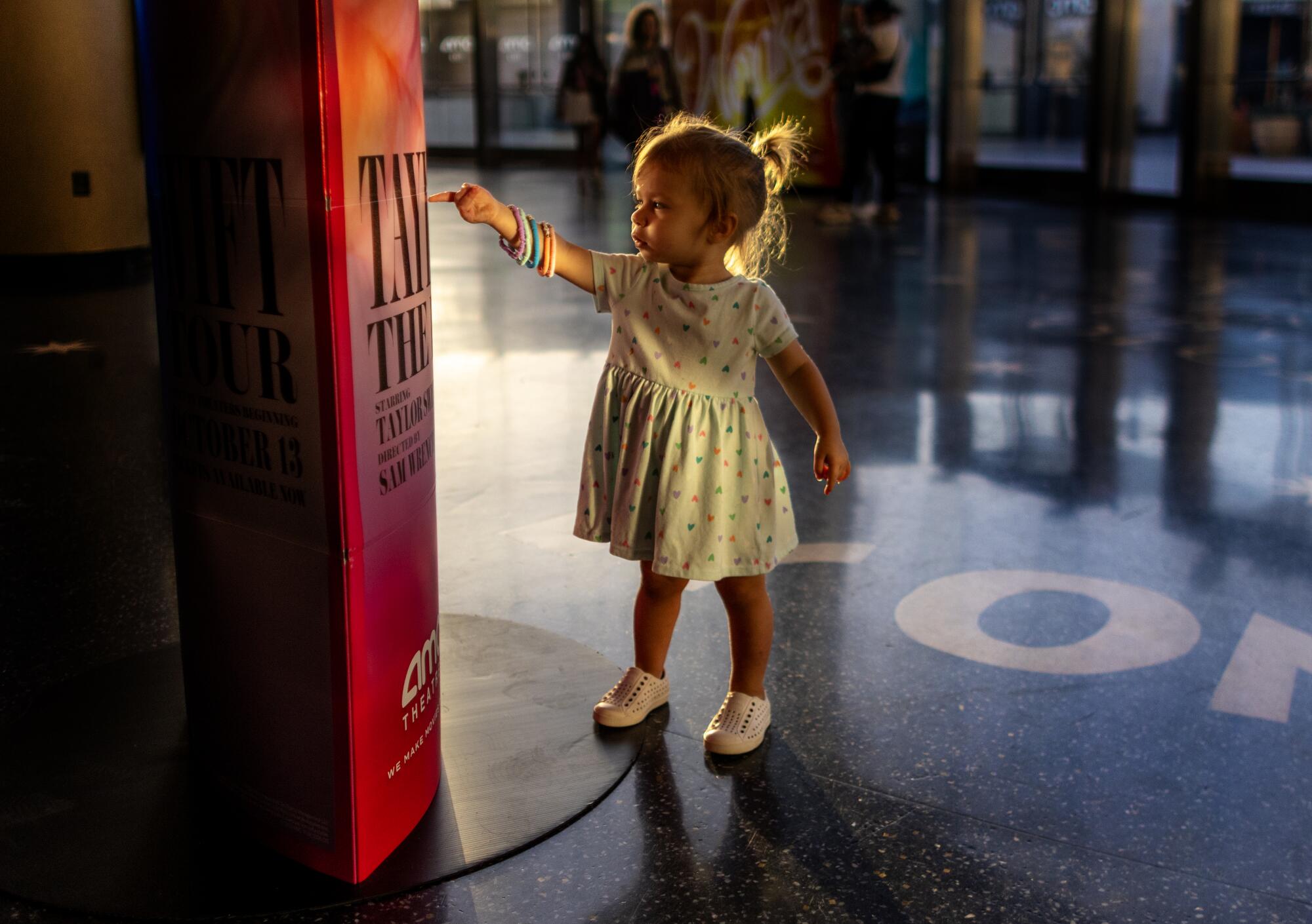 Zealand Birnbaum, 1, of West Hollywood points to a Taylor Swift poster