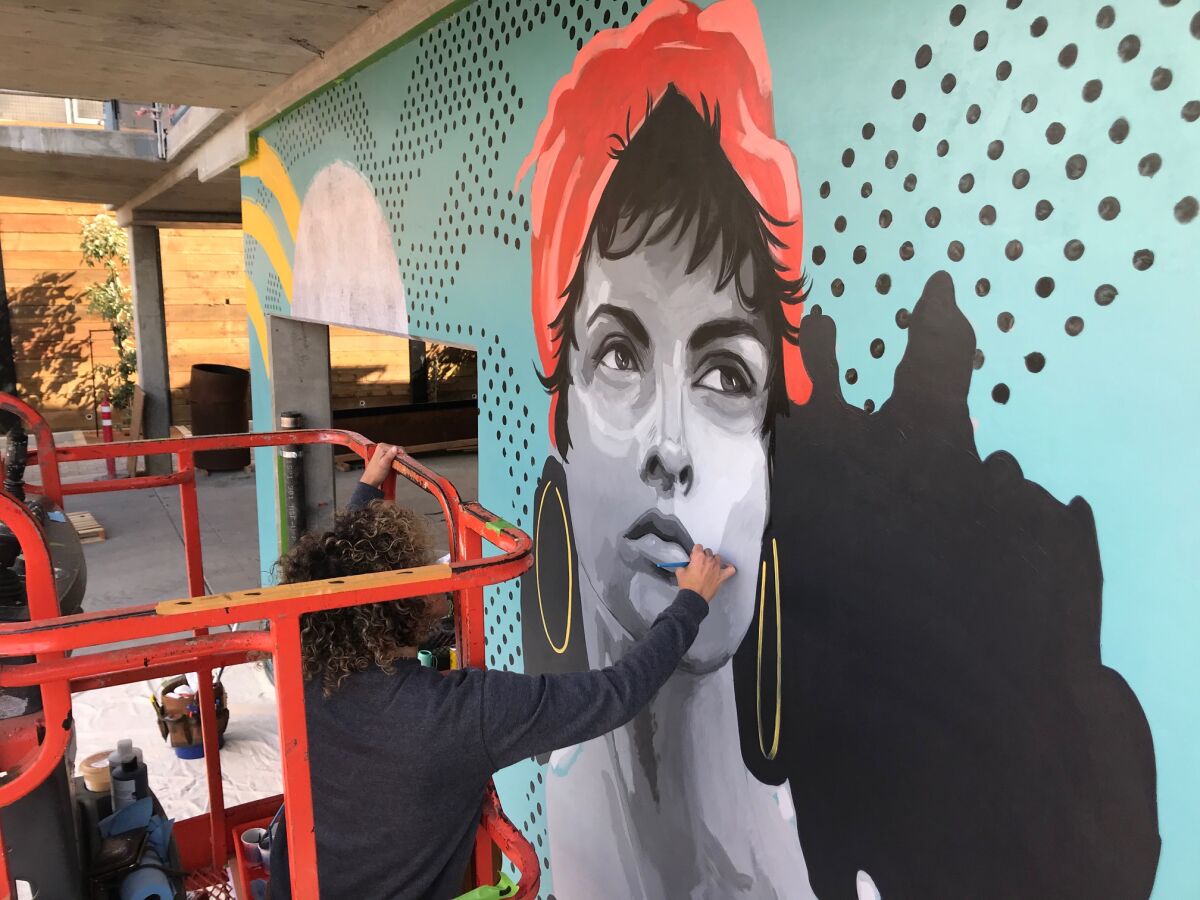 Muralist Tierney Moses at work on the 330 Cedros building.