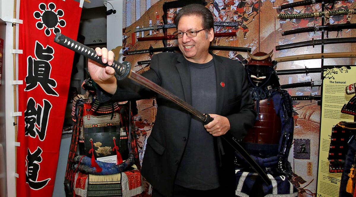 Michael Matsuda of the Burbank Martial Arts History Museum handles one of the many swords he has on display.