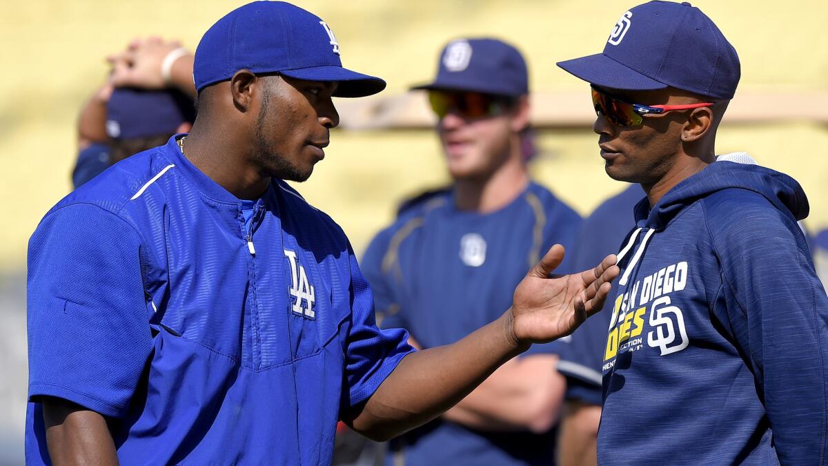 Dodgers right fielder Yasiel Pui chats with San Diego Padres shortstop Alexei Ramirez during batting practice Saturday.
