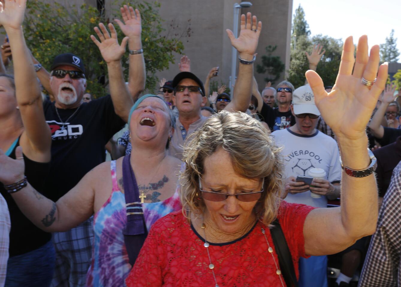 Members of the community pray outside the El Cajon Police Department.