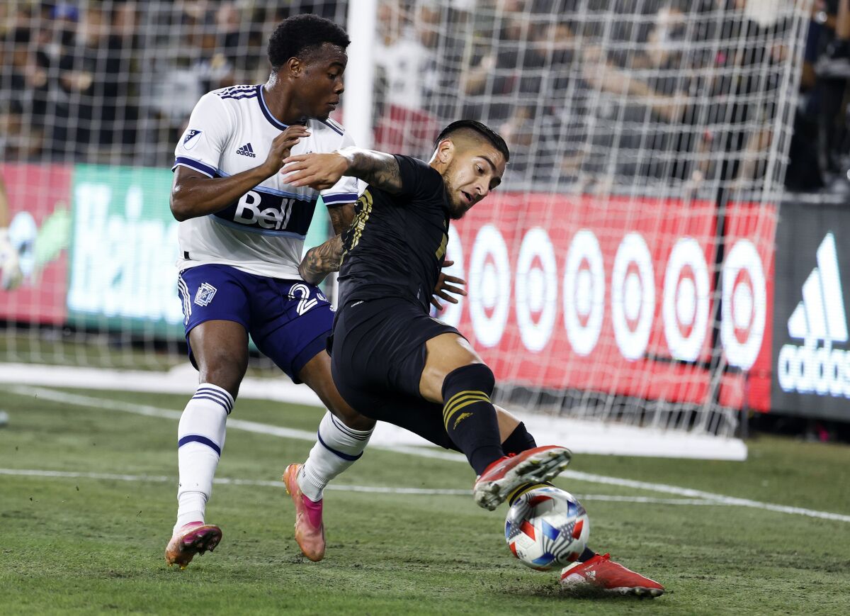 LAFC forward Cristian Arango controls the ball while defended by Vancouver Whitecaps'  Javain Brown.