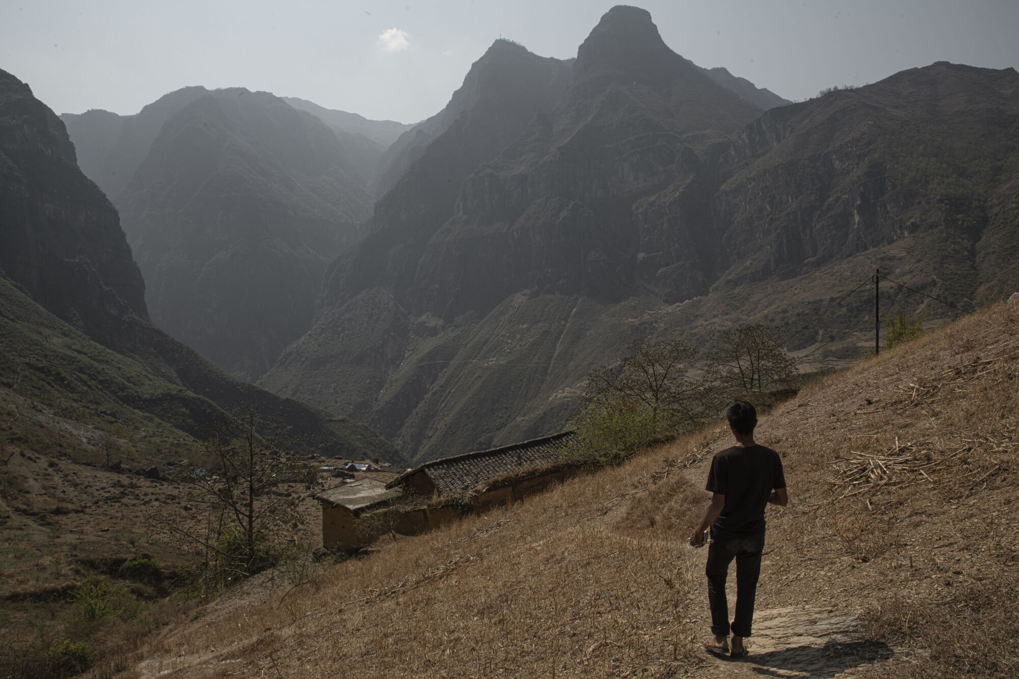 A man walks toward his home atop a cliff 