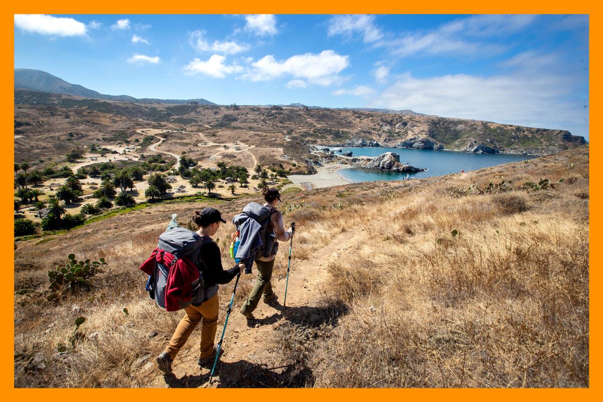 Hikers Erin and sister Jenna Sakamoto arrive at the Little Harbor Campground after hiking the Trans-Catalina Trail.