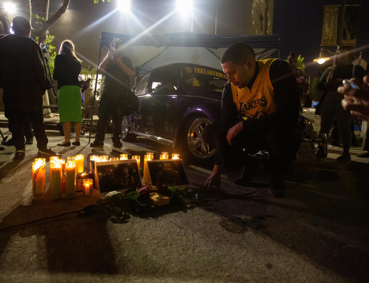 Un fan presenta sus respetos, mientras muchos lloran la muerte de Kobe Bryant en una vigilia en Leimert Park, el domingo, en Los Ángeles.