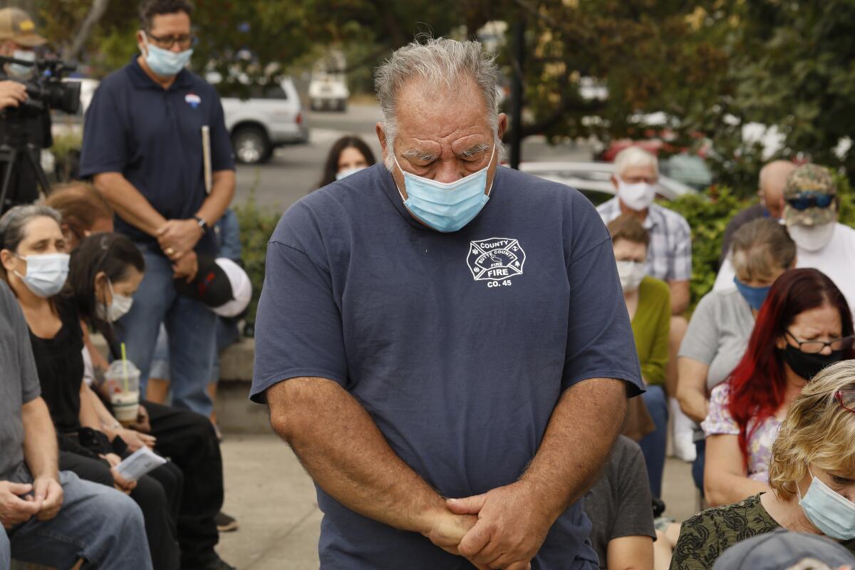 Fire Chief Reed Rankin bows his head during a moment of silence