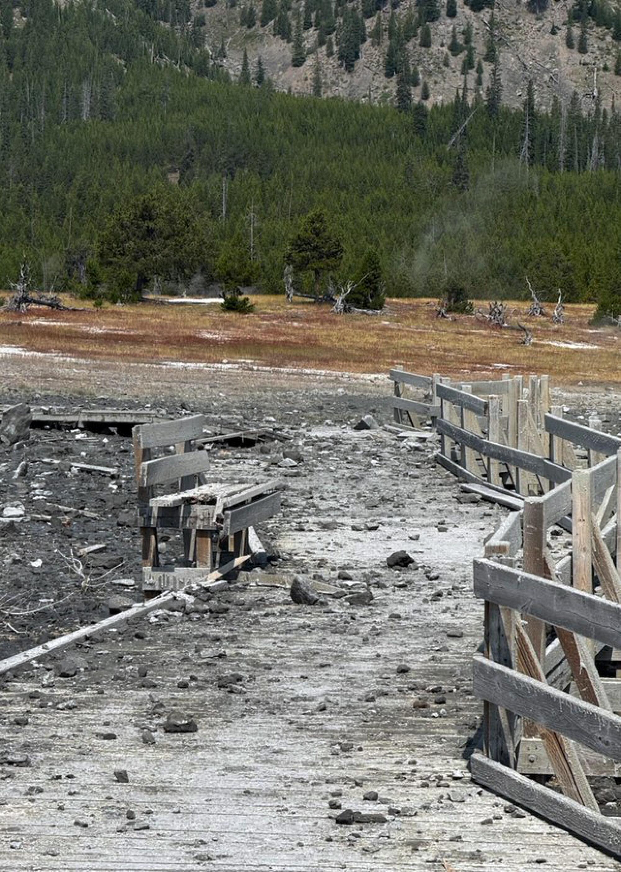 A boardwalk at Yellowstone National Park is covered with mud and debris.