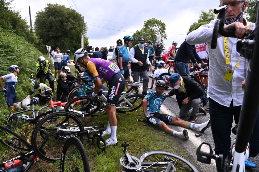 Riders are helped by medical staff members during the 1st stage of the 108th edition of the Tour de France.