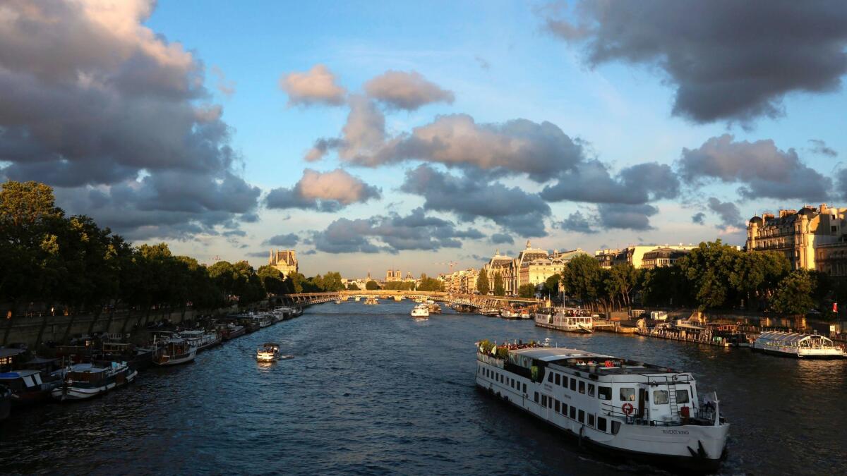 Tourist river boats sail on the Seine in Paris. It's been a banner year for vacation spending, here and abroad.