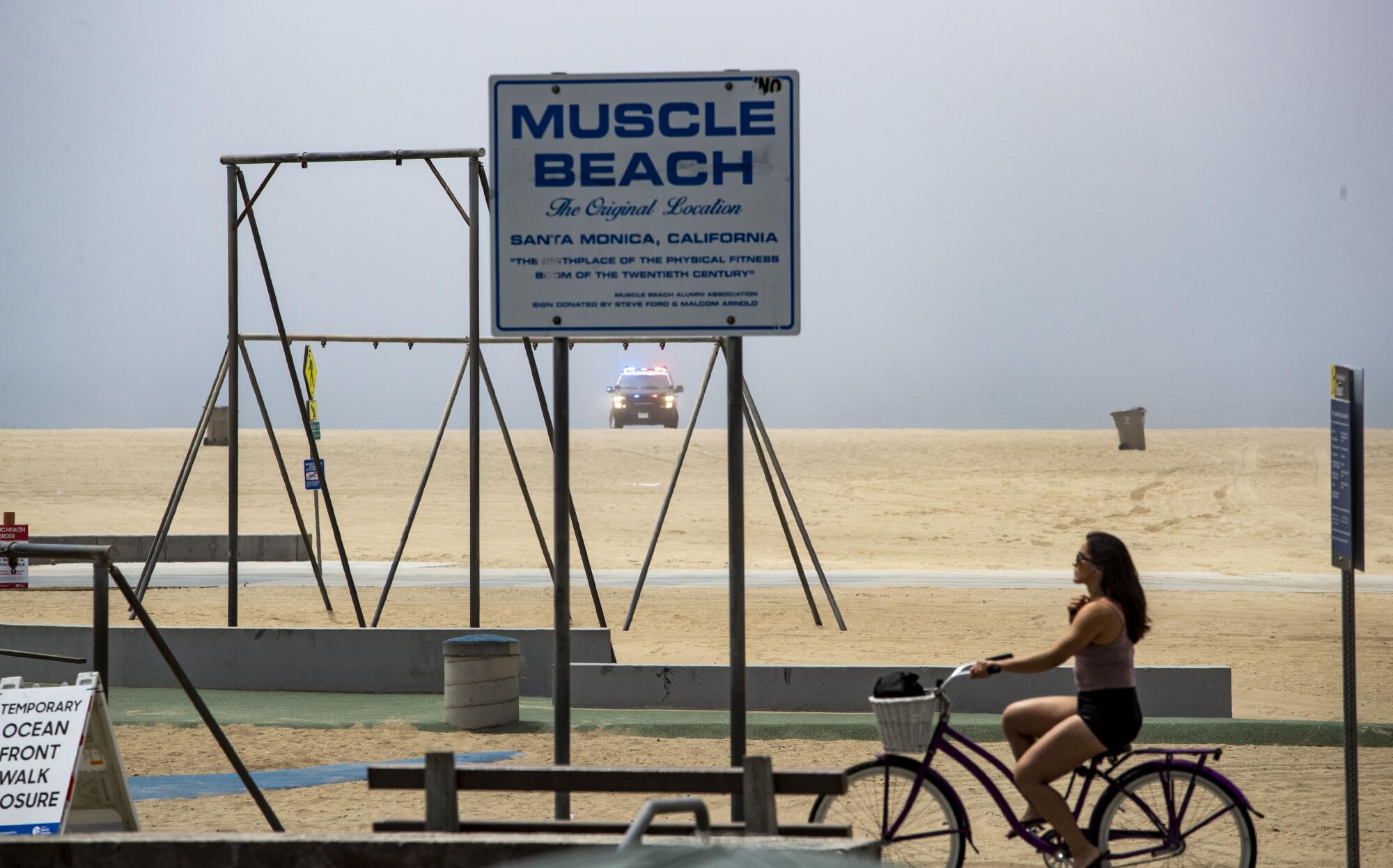 Police keep watch over the empty beach and closed bike path in Santa Monica.