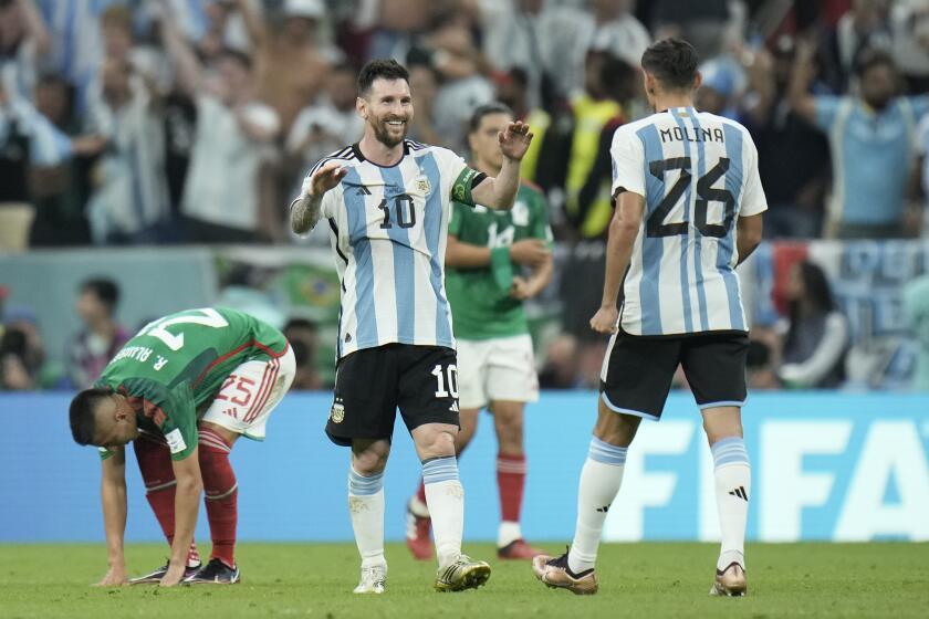 Argentina's Lionel Messi (10) celebrates with Nahuel Molina after a 2-0 win over Mexico in the World Cup on Nov. 26, 2022.