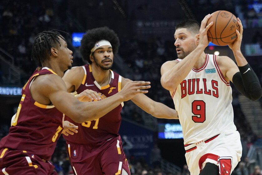 Chicago Bulls' Zach LaVine (8) drives past Cleveland Cavaliers' Isaac Okoro (35) and Jarrett Allen (31) in the first half of an NBA basketball game, Wednesday, Dec. 8, 2021, in Cleveland. (AP Photo/Tony Dejak)
